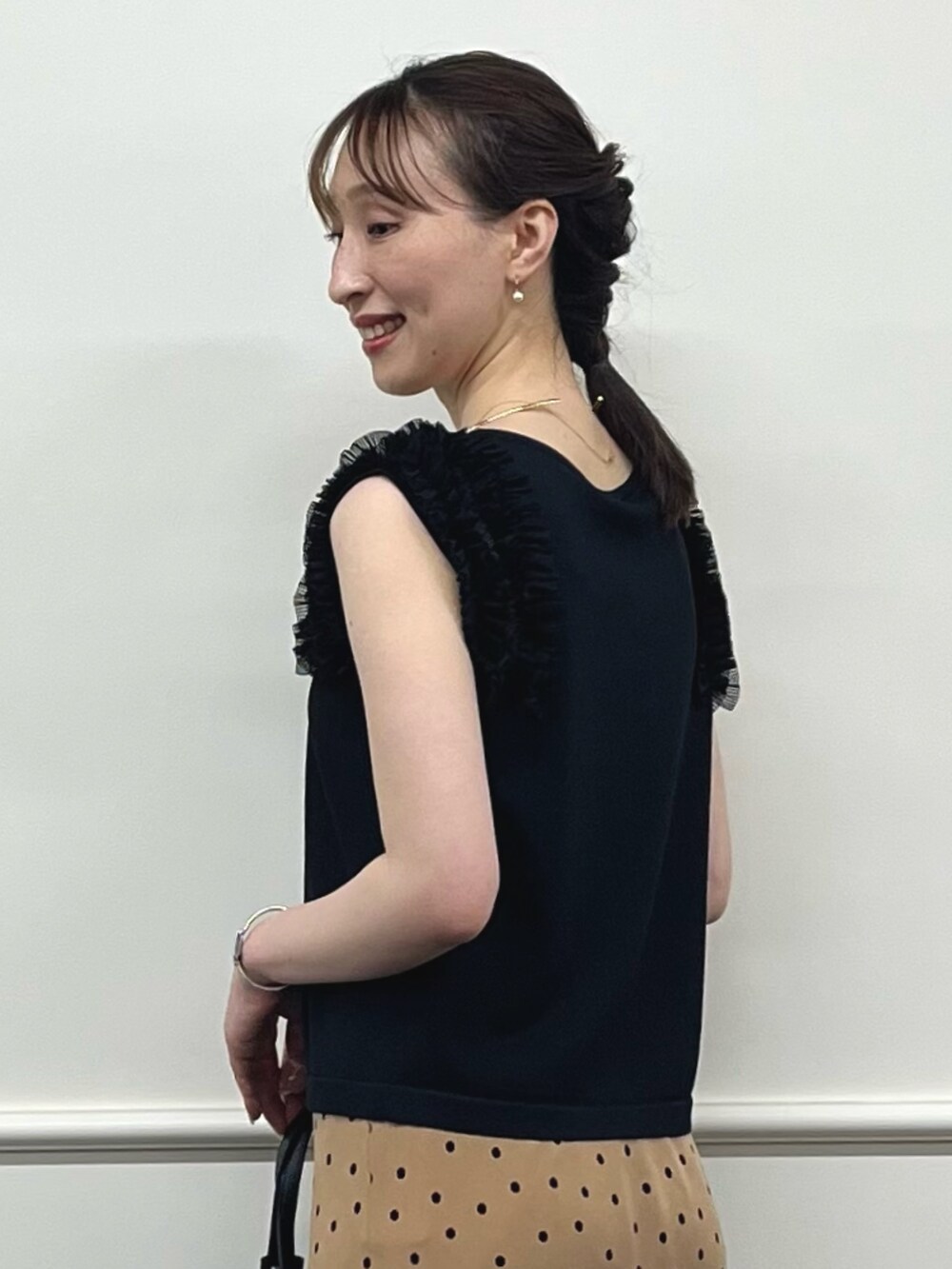 ブラック系のニット/セーター、ブラウン系のスカート、ブラック系のトートバッグを着用したレディースの夏コーディネートの4枚目の写真