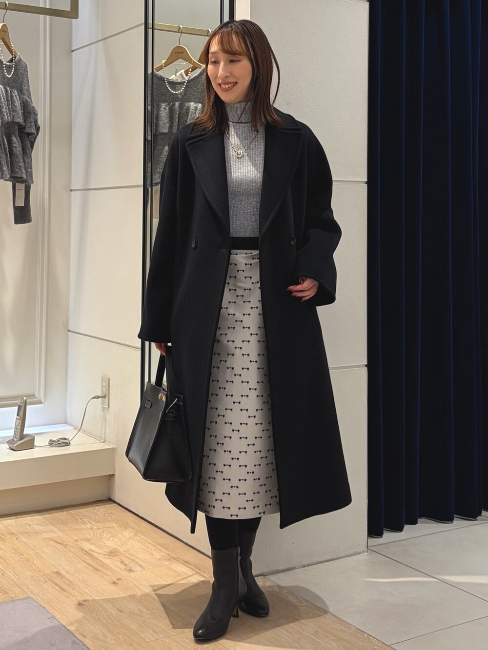 グレー系のその他トップス、ブラック系のその他アウター、ベージュ系のスカートを着用したレディースの冬コーディネートの10枚目の写真