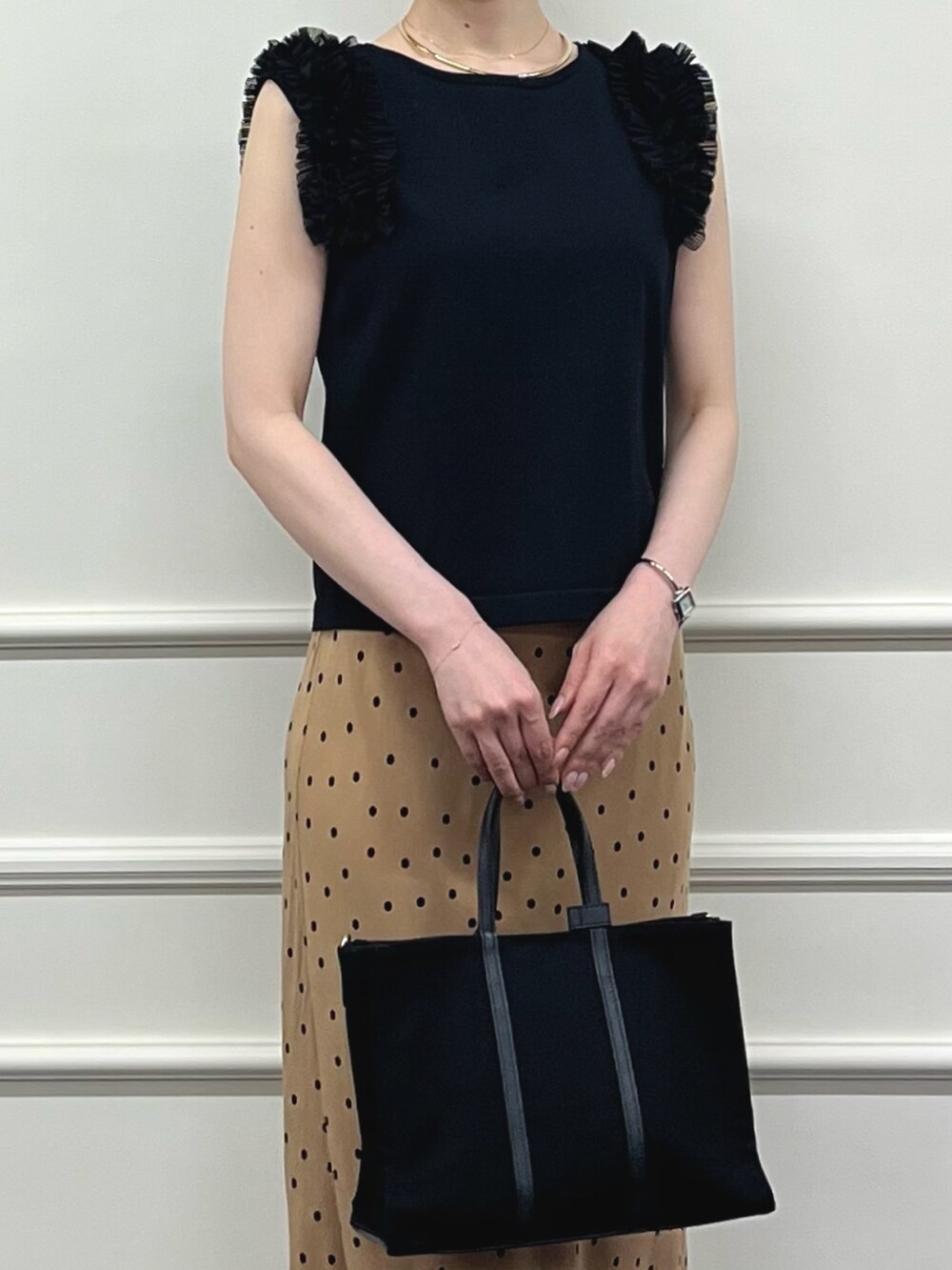 ブラック系のニット/セーター、ブラウン系のスカート、ブラック系のトートバッグを着用したレディースの夏コーディネートの5枚目の写真
