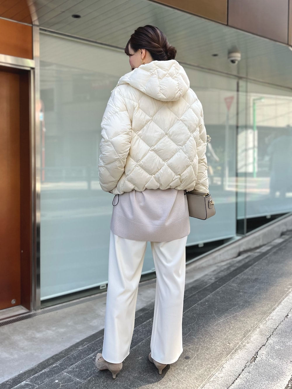 ホワイト系のダウンジャケット/コート、ベージュ系のニット/セーター、ベージュ系のショルダーバッグを着用したレディースの秋コーディネートの6枚目の写真