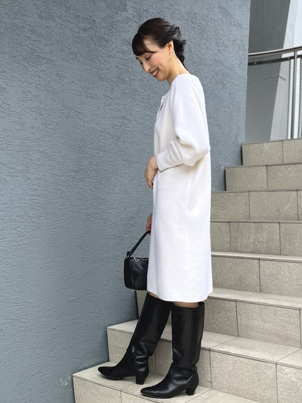 ホワイト系のニット/セーター、ブラック系のショルダーバッグを着用したレディースの秋コーディネートの5枚目の写真