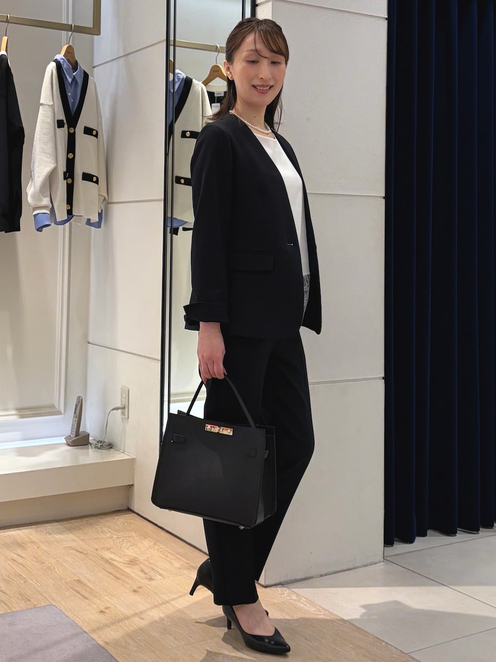 ホワイト系のシャツ/ブラウス、ブルー系のノーカラージャケット、ブラック系のショルダーバッグを着用したレディースの冬コーディネートの9枚目の写真