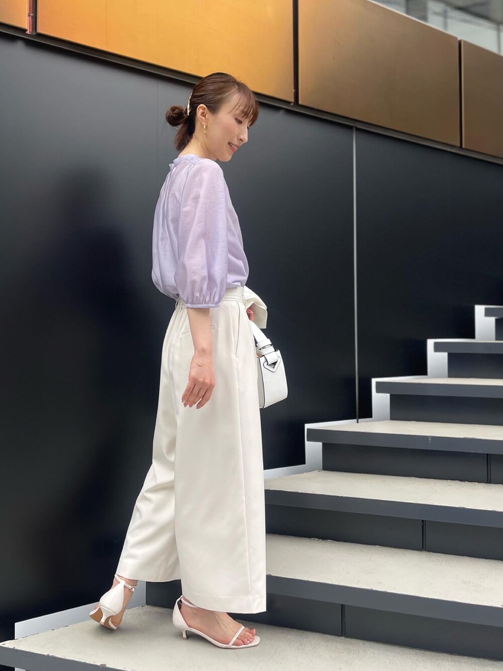 パープル系のシャツ/ブラウス、ホワイト系のその他パンツ、ブラック系のハンドバッグを着用したレディースの春コーディネートの4枚目の写真