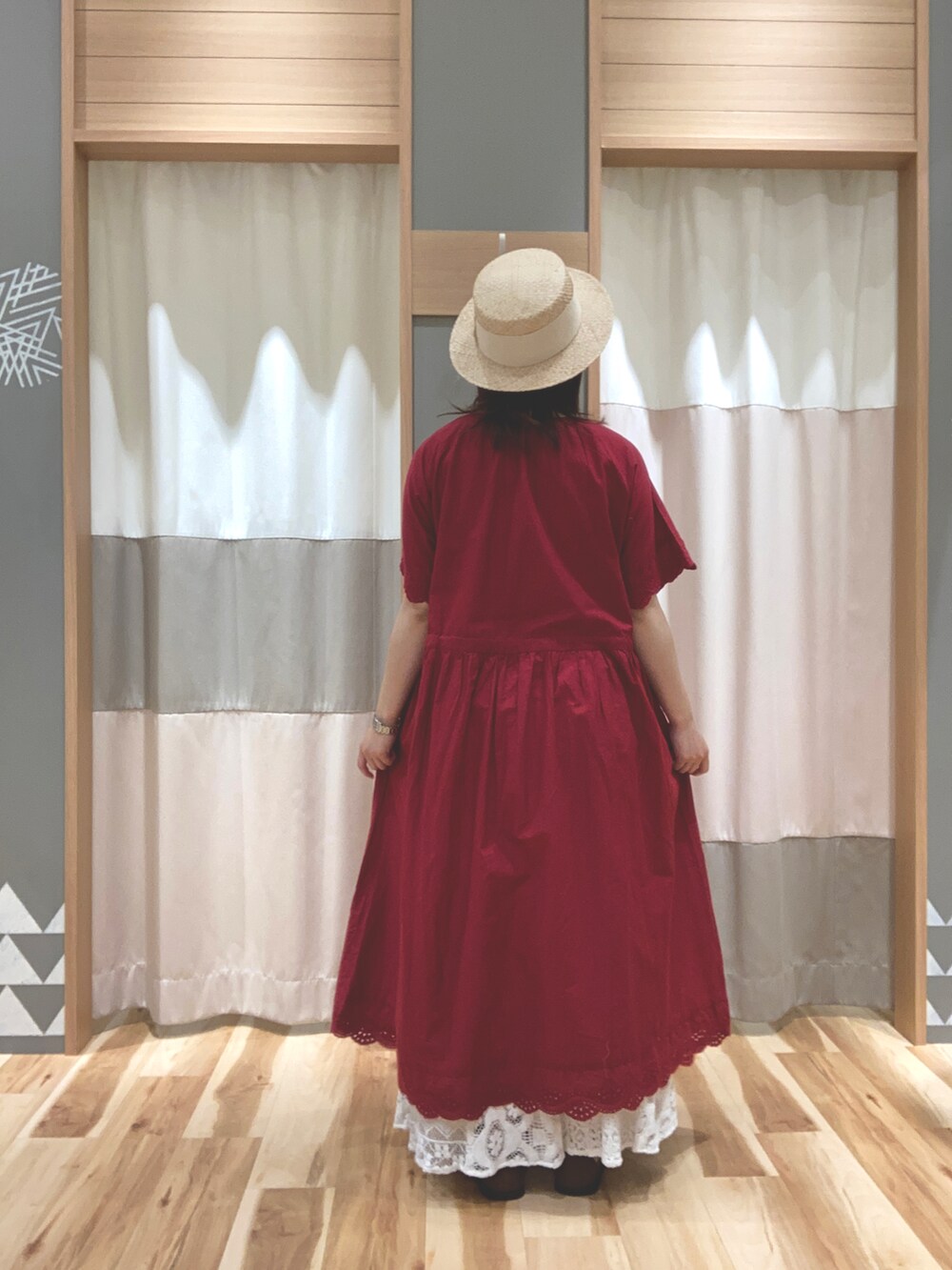 レッド系のワンピース、ホワイト系のスカート、ホワイト系のTシャツ/カットソーを着用したレディースの夏コーディネートの2枚目の写真