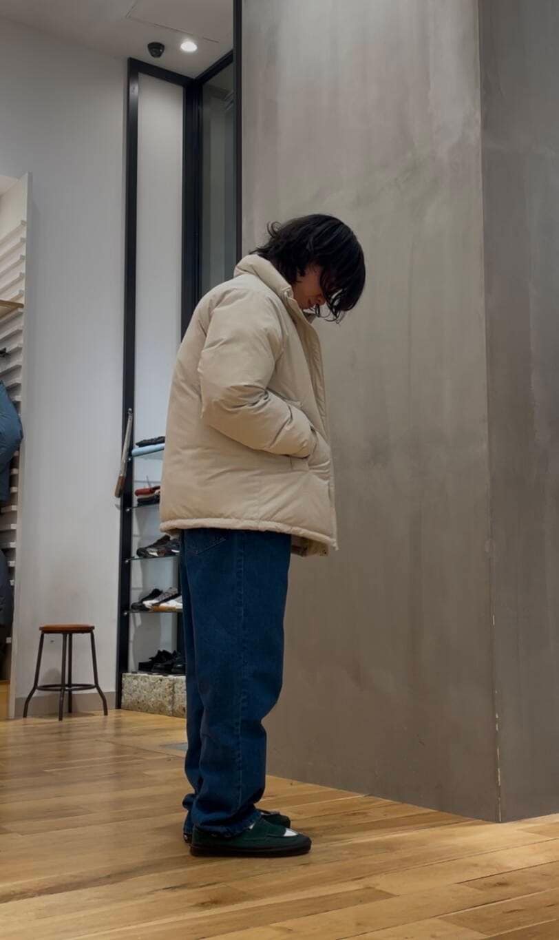 ブルー系のデニムパンツ、ブルー系のニット/セーター、ホワイト系のブルゾンを着用したメンズの冬コーディネートの2枚目の写真