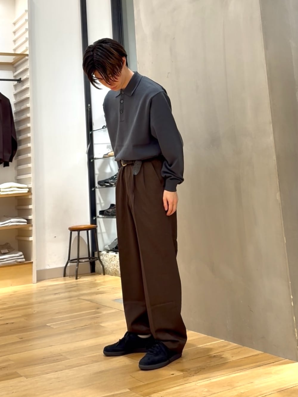 グリーン系のポロシャツ、ブラウン系のその他パンツ、ブラック系のスニーカーを着用したメンズの秋コーディネートの2枚目の写真