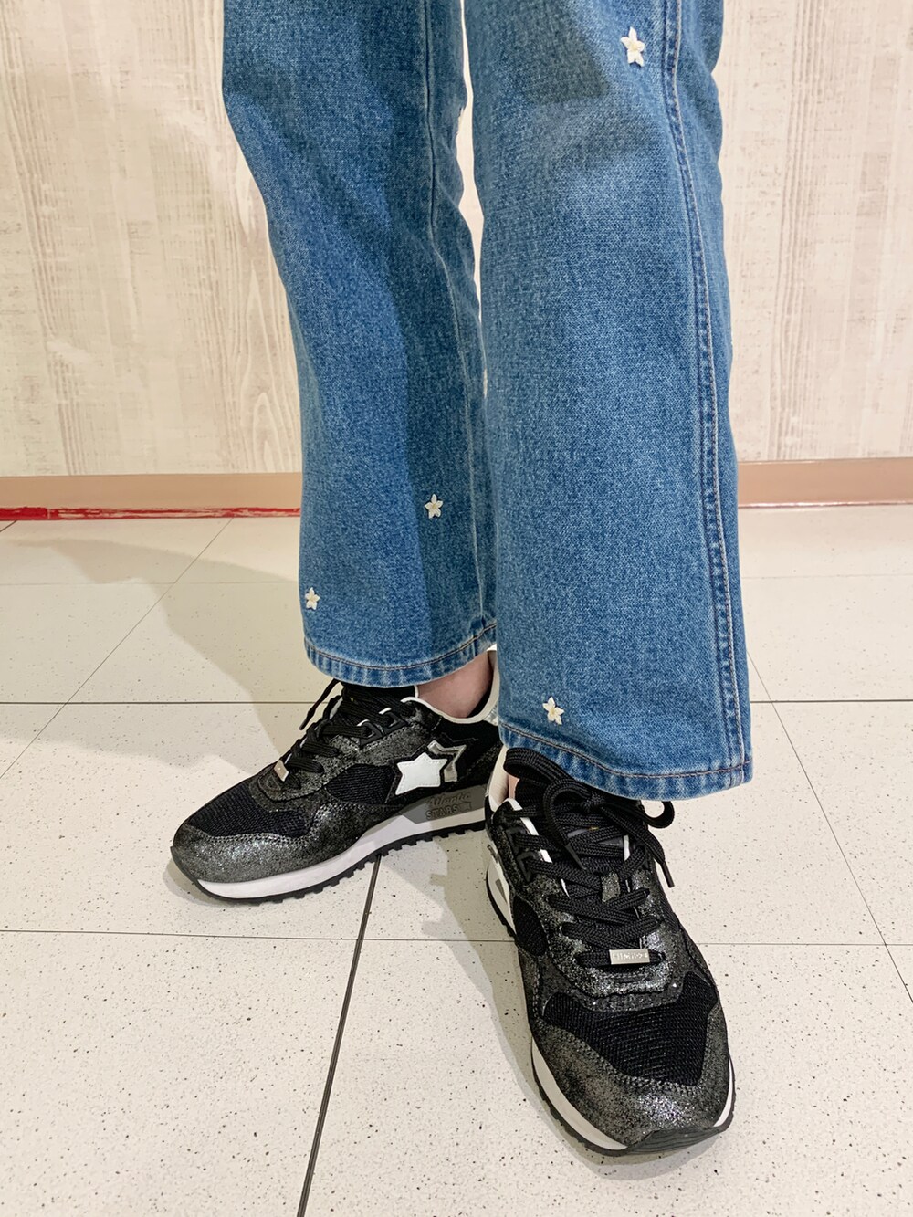 ブラック系のスニーカー、ホワイト系のシャツ/ブラウス、ブルー系のデニムパンツを着用したレディースの春コーディネートの3枚目の写真