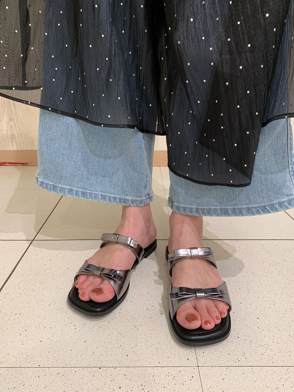 ブラウン系のTシャツ/カットソー、ブラック系のワンピース、その他のサンダルを着用したレディースの春コーディネートの3枚目の写真