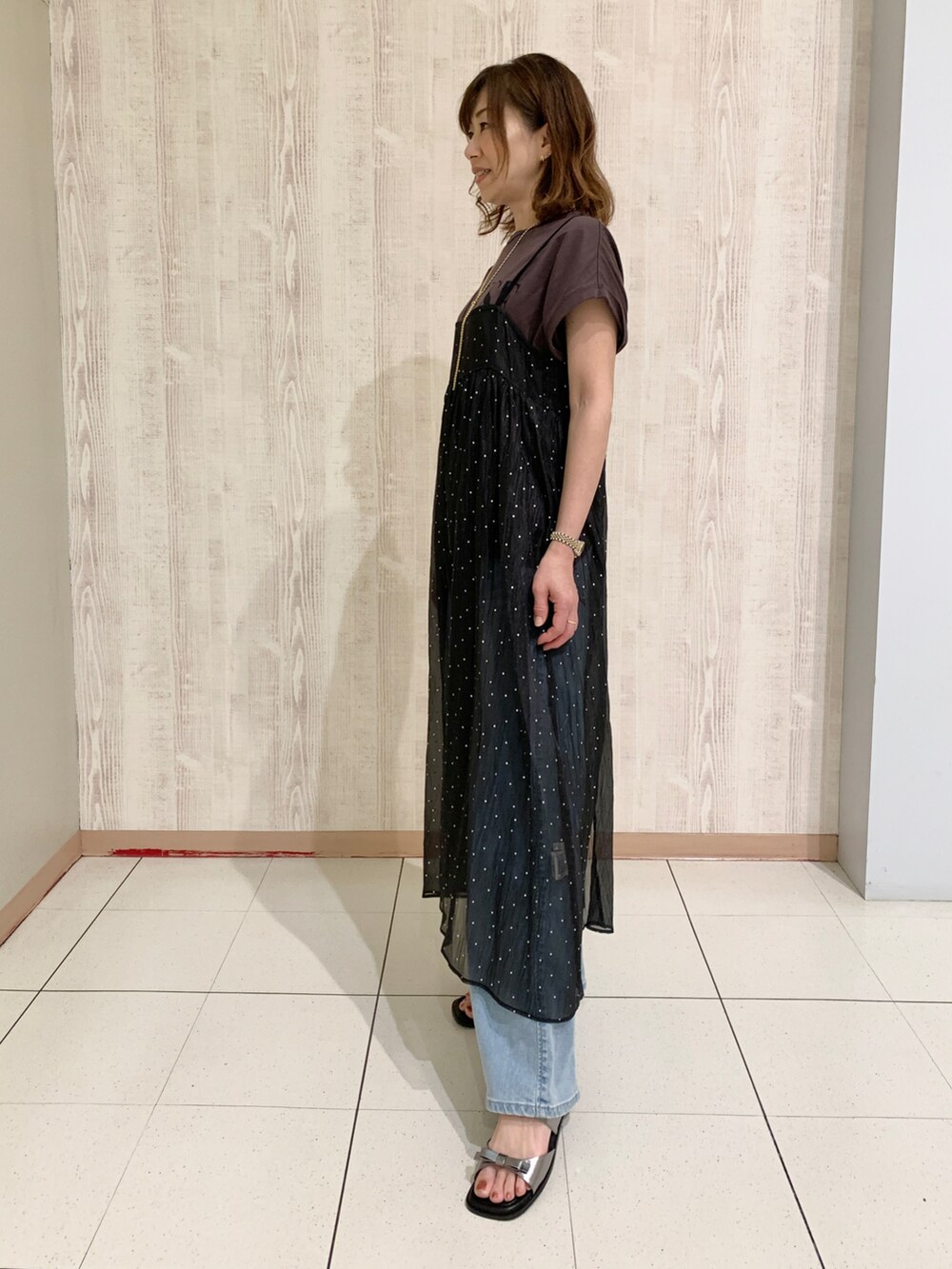 ブラウン系のTシャツ/カットソー、ブラック系のワンピース、その他のサンダルを着用したレディースの春コーディネートの2枚目の写真