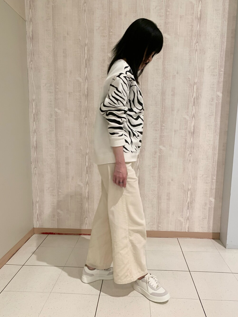 ホワイト系のスウェット、ホワイト系のスニーカーを着用したレディースの冬コーディネートの2枚目の写真