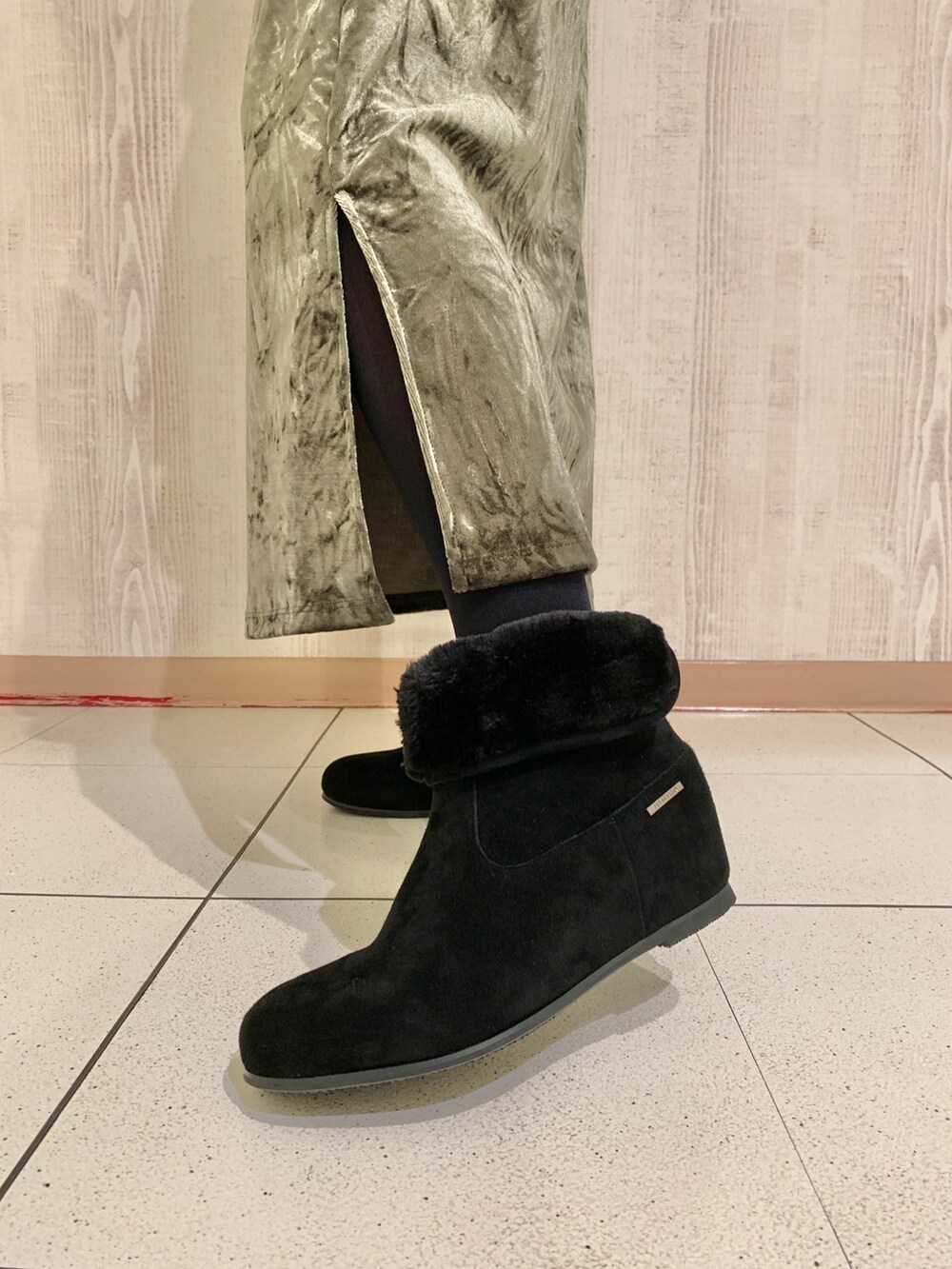 ブラック系のニット/セーター、グリーン系のスカート、ブラック系のブーツを着用したレディースの秋コーディネートの3枚目の写真