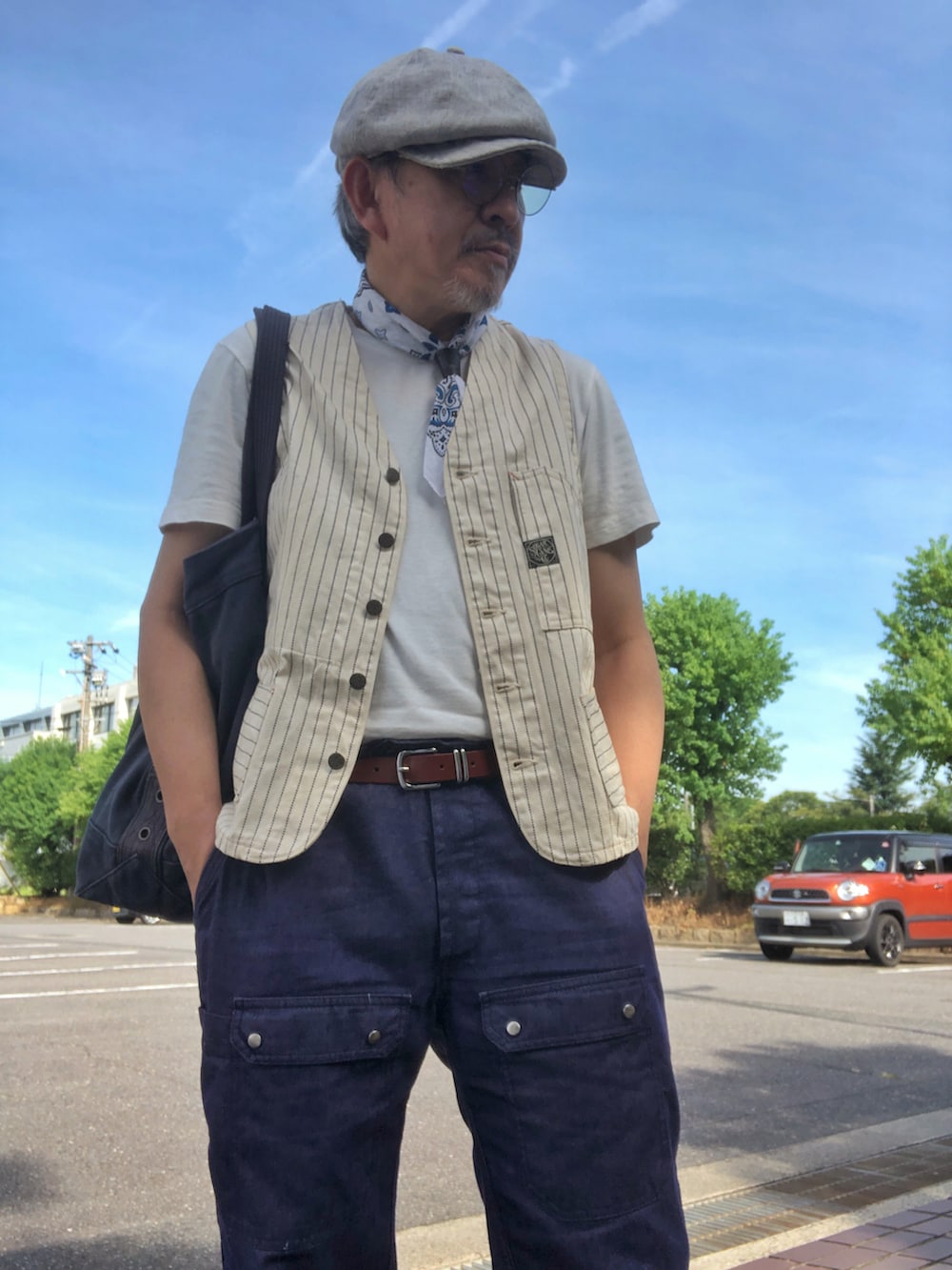 ホワイト系のTシャツ/カットソー、ホワイト系のベスト、ブルー系のデニムパンツを着用したメンズの夏コーディネートの2枚目の写真