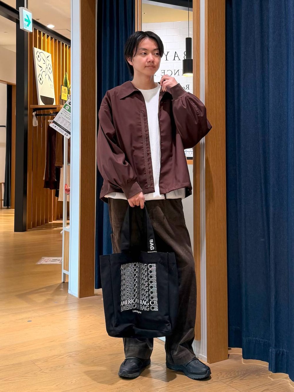 ブラック系のトートバッグ、ブラウン系のその他パンツ、ホワイト系のスウェットを着用したメンズの冬コーディネートの2枚目の写真