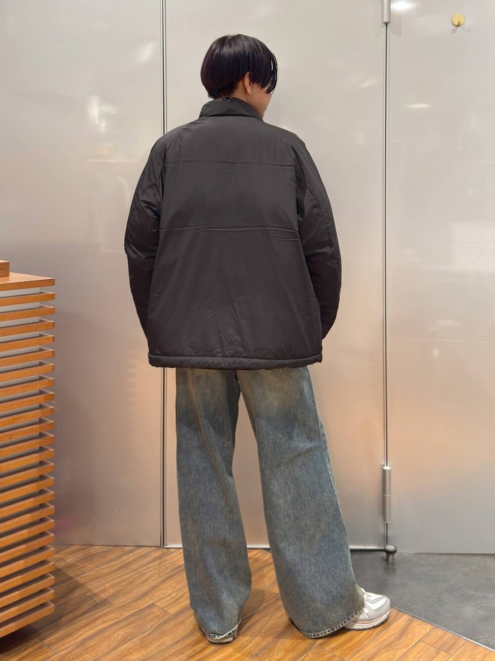 ブラック系のダウンジャケット/コート、ブラウン系のデニムパンツ、その他のスウェットを着用したメンズの冬コーディネートの2枚目の写真