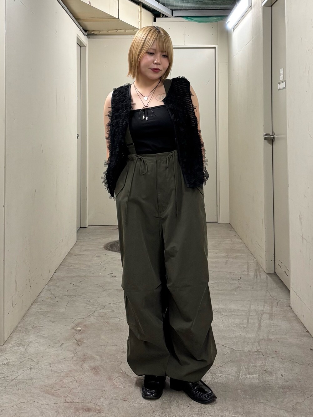 ブラック系のキャミソール、ブラック系のベスト、グリーン系のその他パンツを着用したレディースの秋コーディネートの2枚目の写真