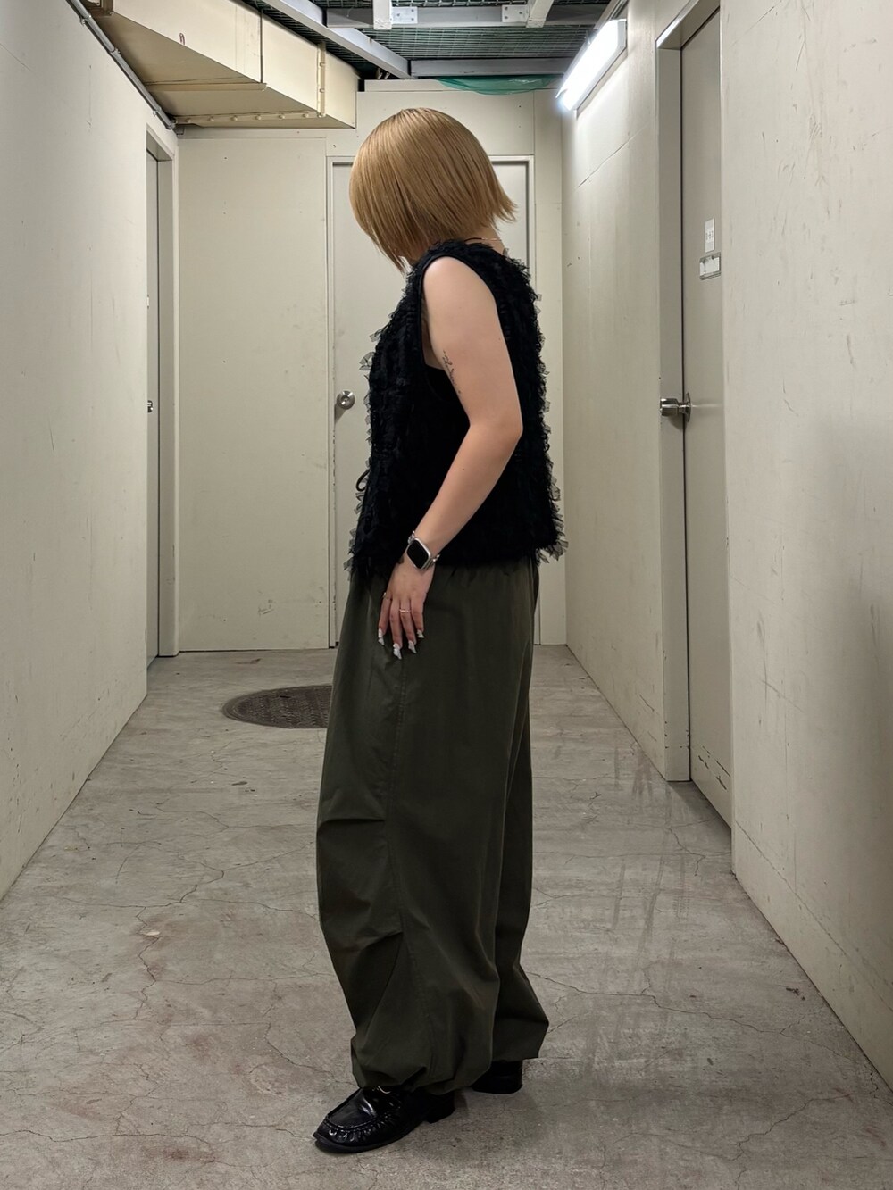 ブラック系のキャミソール、ブラック系のベスト、グリーン系のその他パンツを着用したレディースの秋コーディネートの5枚目の写真