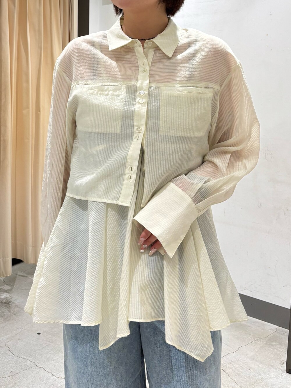 ベージュ系のボストンバッグ、ホワイト系のシャツ/ブラウス、ブルー系のデニムパンツを着用したレディースの春コーディネートの7枚目の写真