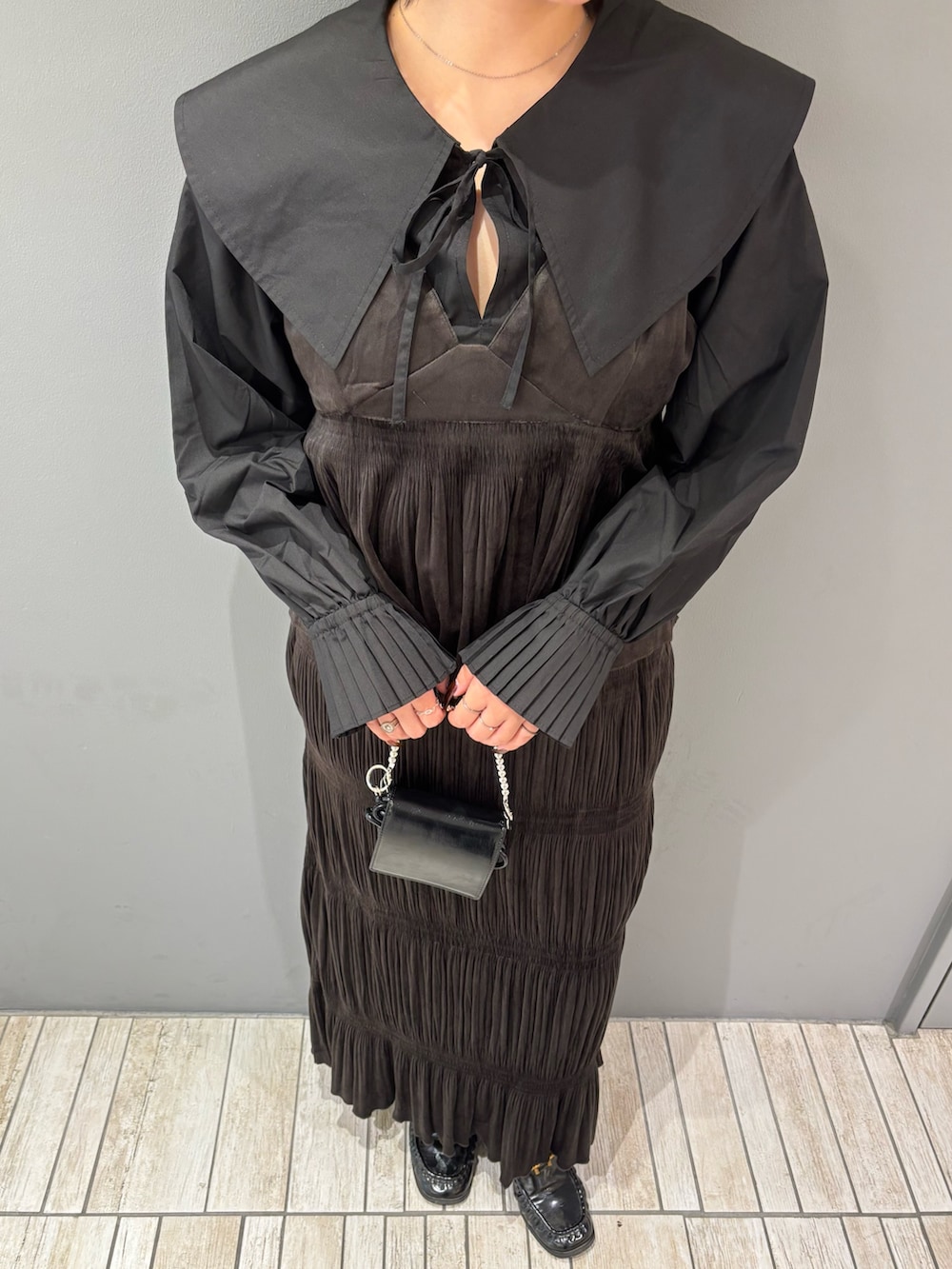 ブラック系のシャツ/ブラウス、ブラウン系のワンピース、ブラック系のローファーを着用したレディースの秋コーディネートの8枚目の写真