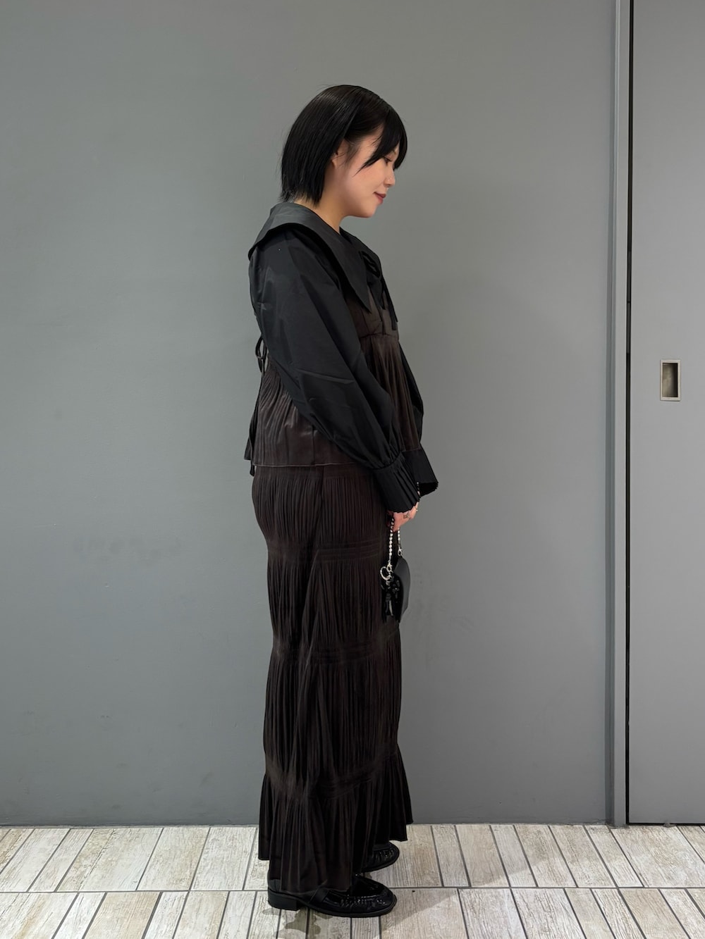 ブラック系のシャツ/ブラウス、ブラウン系のワンピース、ブラック系のローファーを着用したレディースの秋コーディネートの5枚目の写真