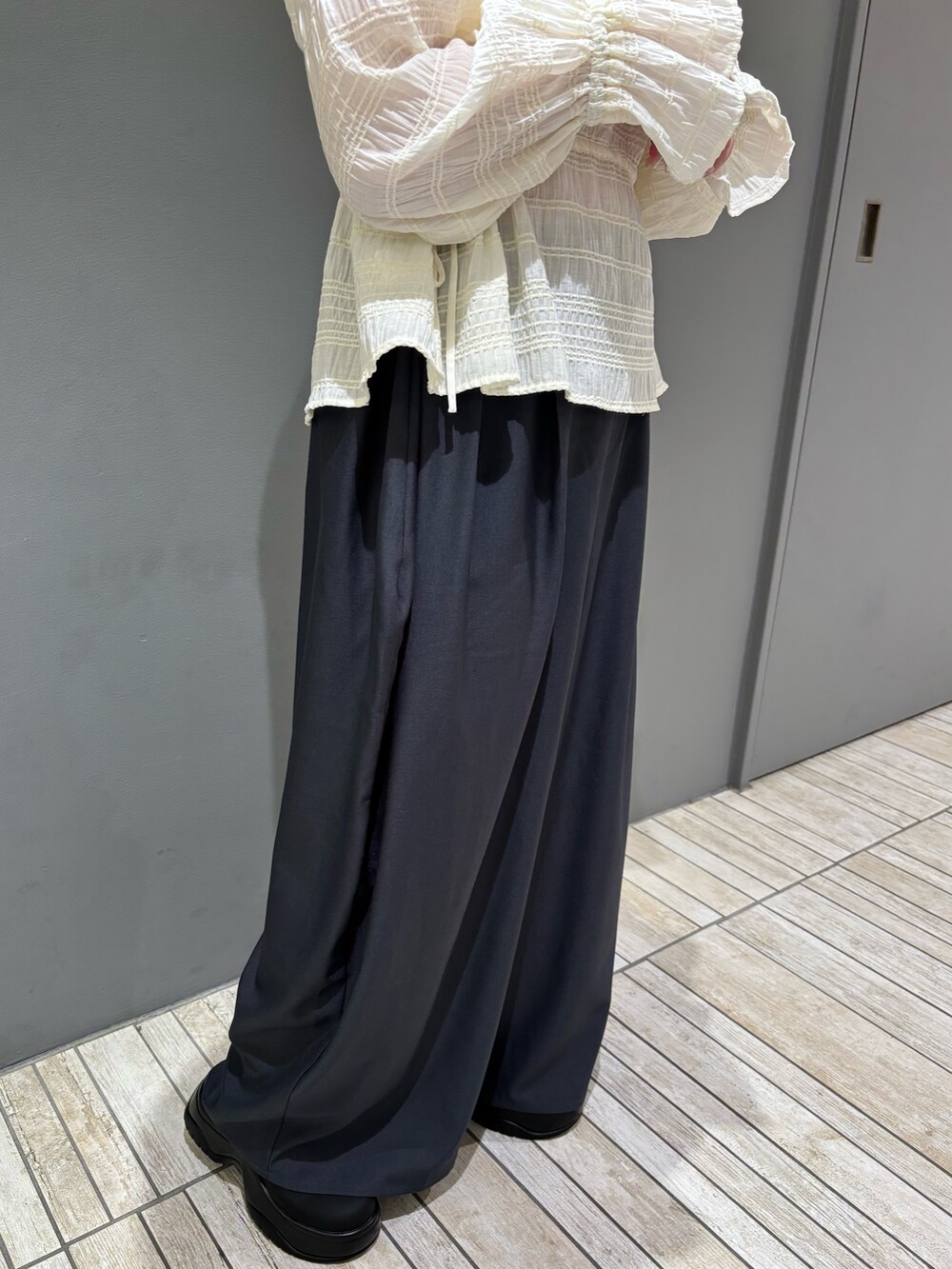 グレー系のその他パンツ、ホワイト系のシャツ/ブラウス、ブラック系のサンダルを着用したレディースの冬コーディネートの4枚目の写真