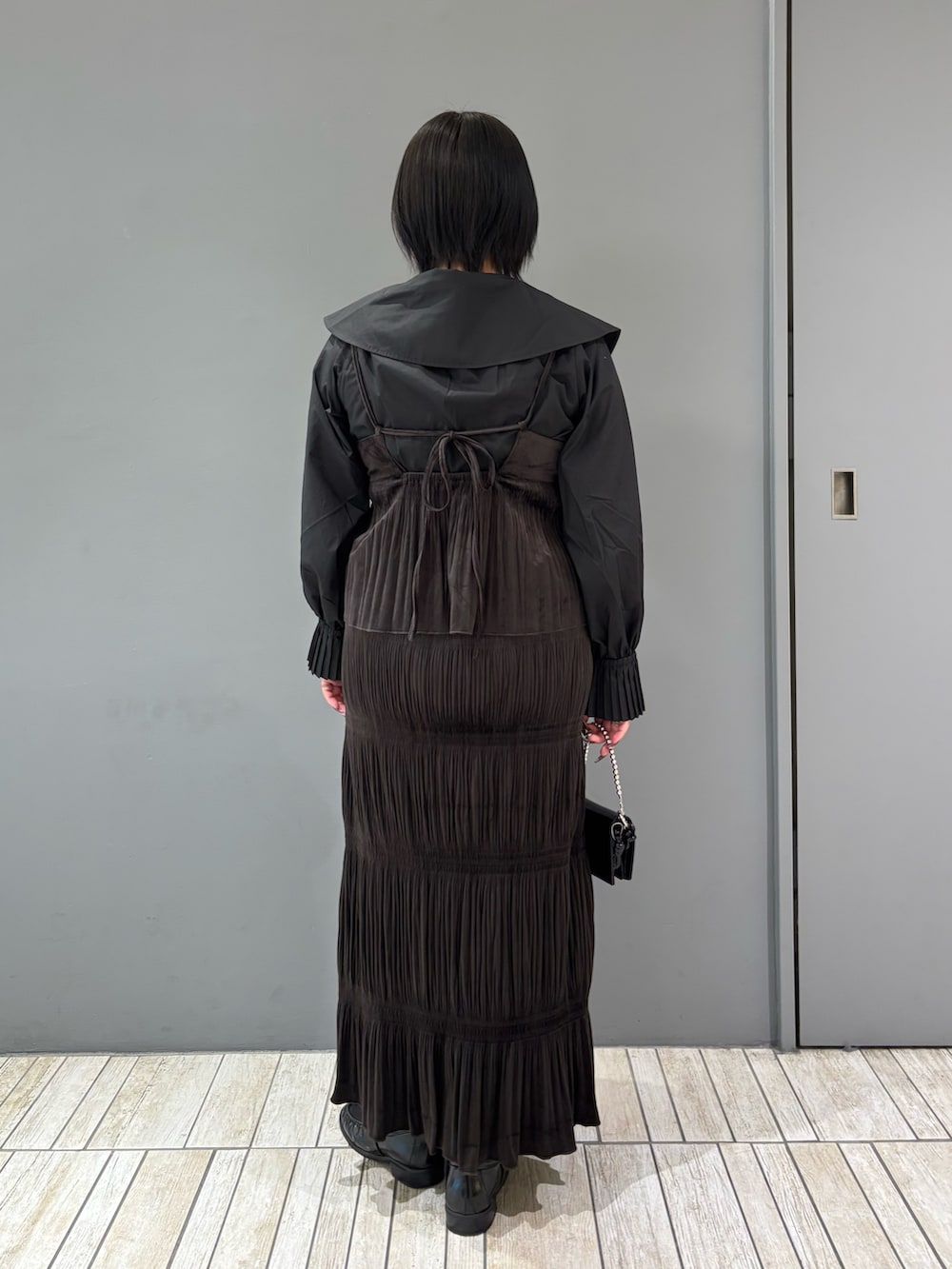 ブラック系のシャツ/ブラウス、ブラウン系のワンピース、ブラック系のローファーを着用したレディースの秋コーディネートの4枚目の写真