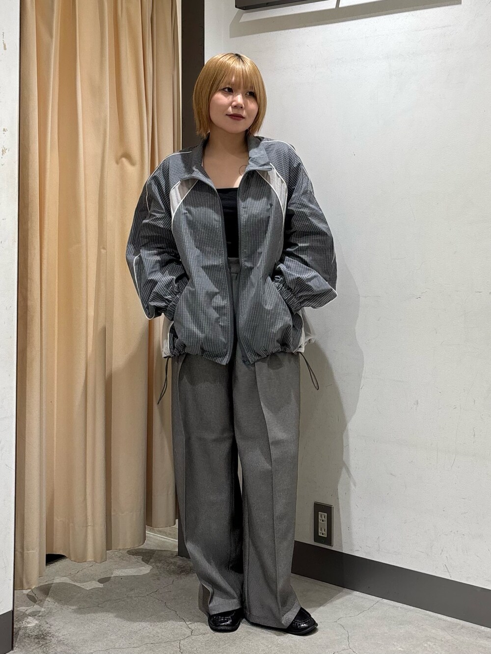 ブラック系のキャミソール、グレー系のブルゾン、グレー系のその他パンツを着用したレディースの秋コーディネートの7枚目の写真