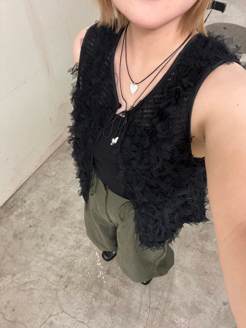 ブラック系のキャミソール、ブラック系のベスト、グリーン系のその他パンツを着用したレディースの秋コーディネートの7枚目の写真