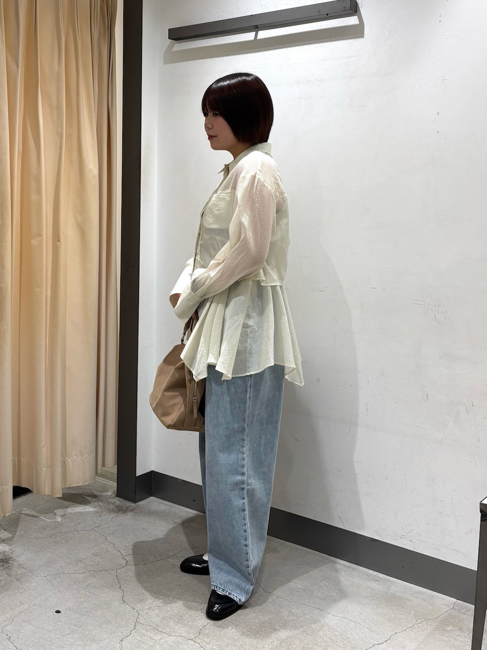 ベージュ系のボストンバッグ、ホワイト系のシャツ/ブラウス、ブルー系のデニムパンツを着用したレディースの春コーディネートの5枚目の写真