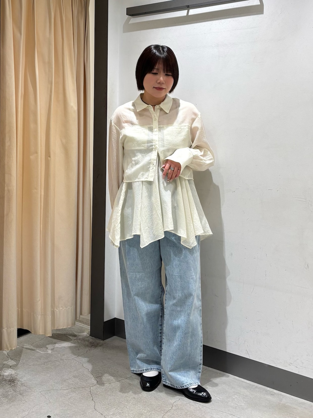 ベージュ系のボストンバッグ、ホワイト系のシャツ/ブラウス、ブルー系のデニムパンツを着用したレディースの春コーディネートの4枚目の写真