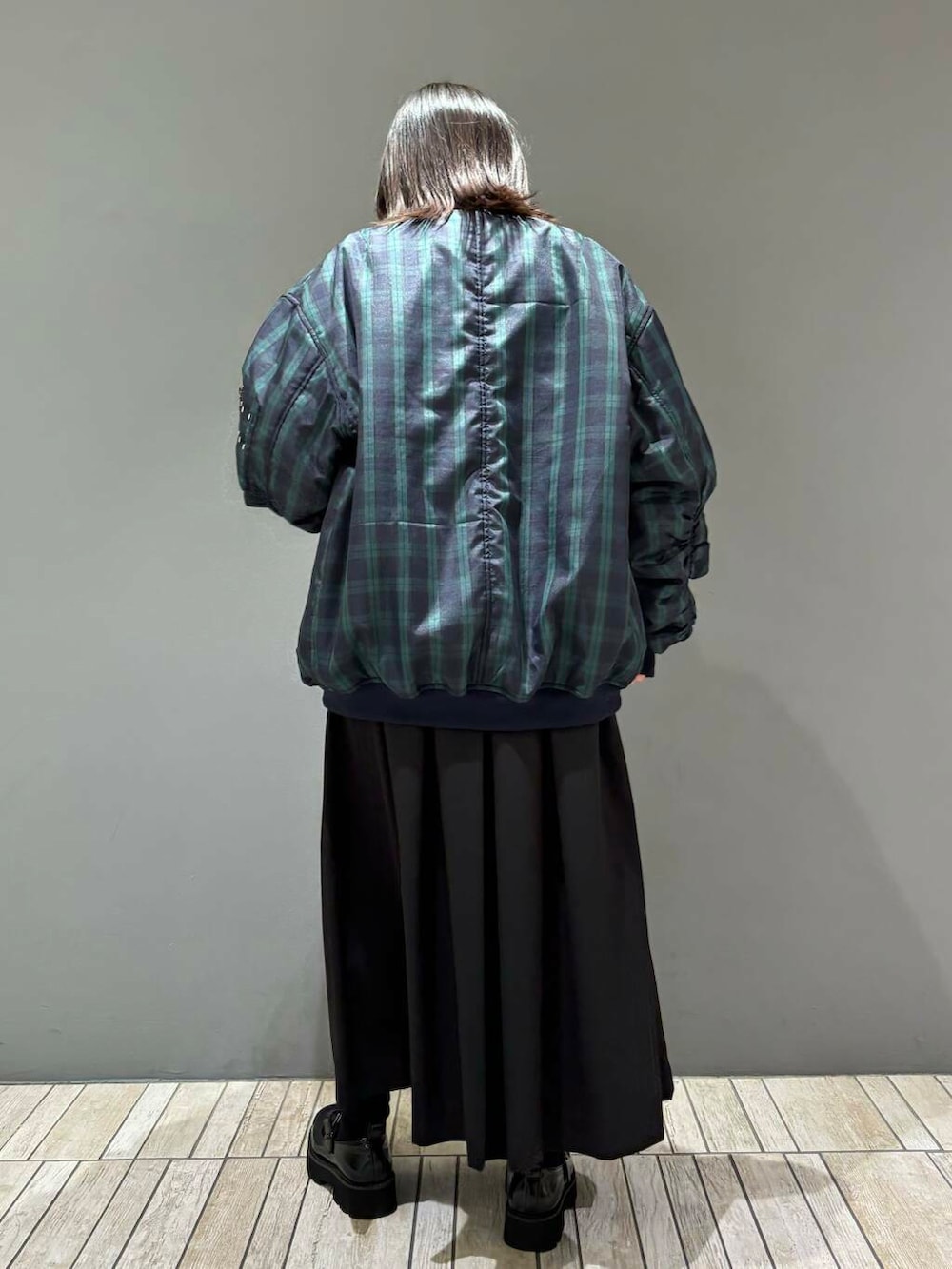 ブルー系のTシャツ/カットソー、ブラック系のワンピース、ブラック系のMA-1を着用したレディースの秋コーディネートの4枚目の写真