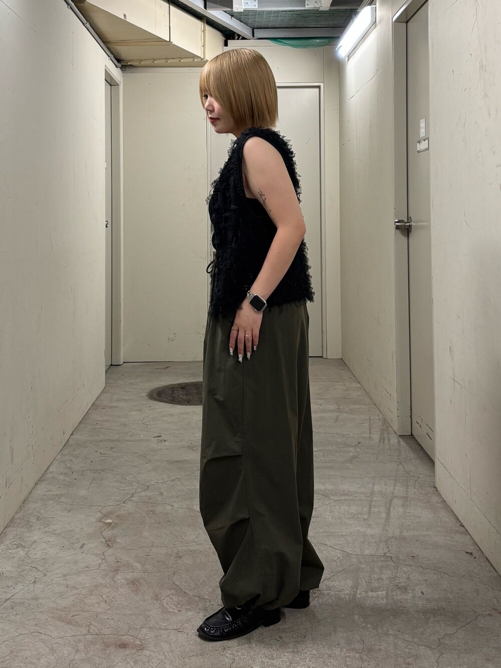 ブラック系のキャミソール、ブラック系のベスト、グリーン系のその他パンツを着用したレディースの秋コーディネートの4枚目の写真