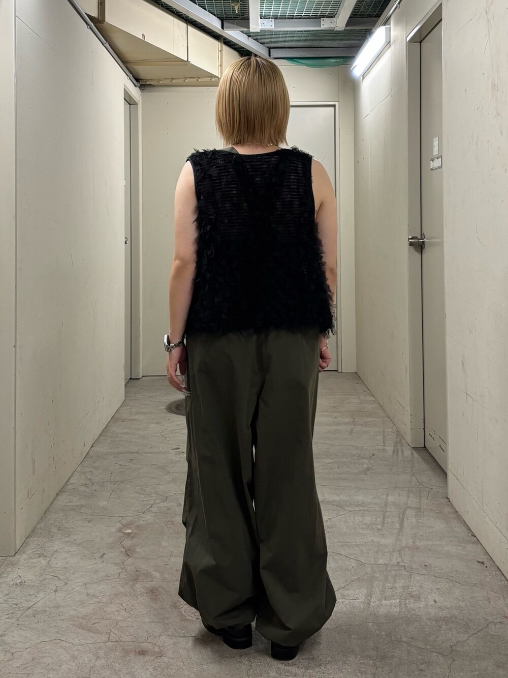 ブラック系のキャミソール、ブラック系のベスト、グリーン系のその他パンツを着用したレディースの秋コーディネートの6枚目の写真