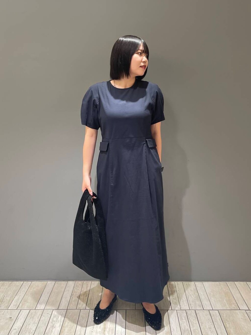 ブルー系のワンピース、ブラック系のトートバッグ、ブラック系のその他シューズを着用したレディースの夏コーディネートの2枚目の写真