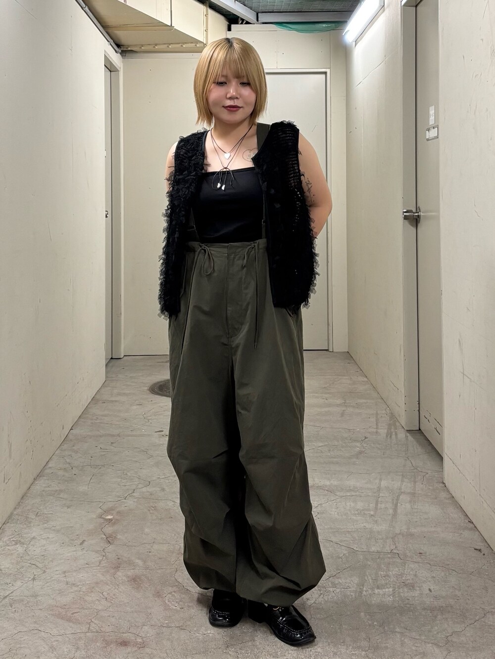 ブラック系のキャミソール、ブラック系のベスト、グリーン系のその他パンツを着用したレディースの秋コーディネートの3枚目の写真