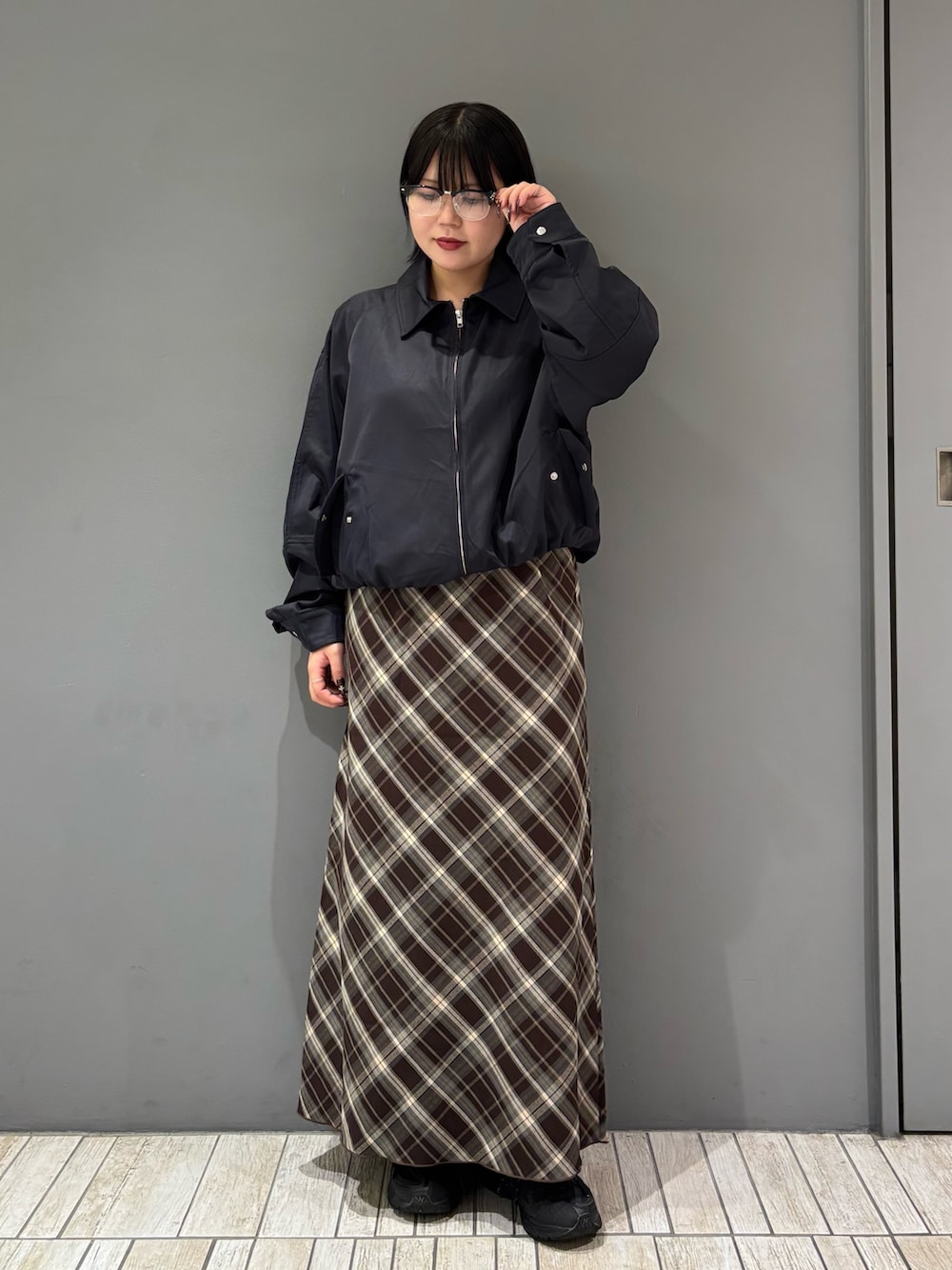 ブルー系のブルゾン、ブラウン系のスカート、ブラック系のメガネを着用したレディースの秋コーディネートの3枚目の写真