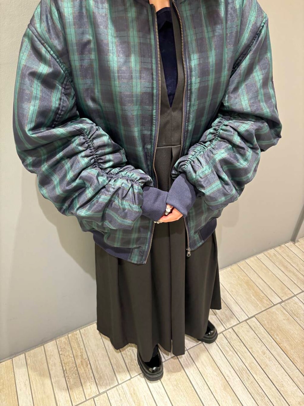 ブルー系のTシャツ/カットソー、ブラック系のワンピース、ブラック系のMA-1を着用したレディースの秋コーディネートの6枚目の写真