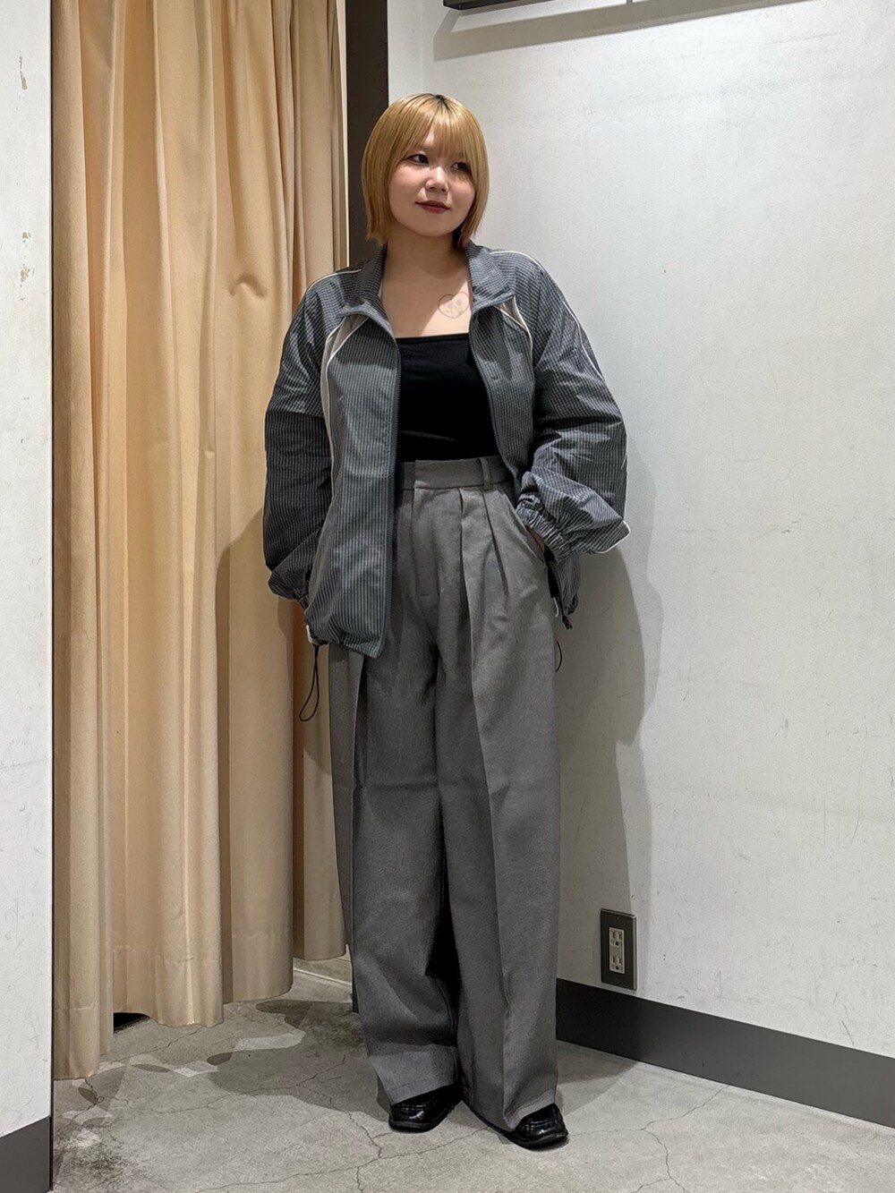 ブラック系のキャミソール、グレー系のブルゾン、グレー系のその他パンツを着用したレディースの秋コーディネートの3枚目の写真