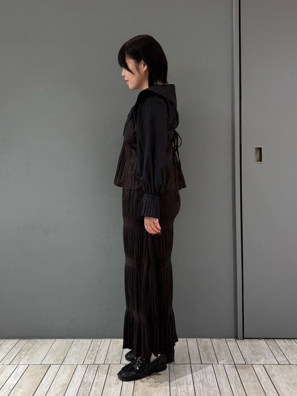 ブラック系のシャツ/ブラウス、ブラウン系のワンピース、ブラック系のローファーを着用したレディースの秋コーディネートの3枚目の写真