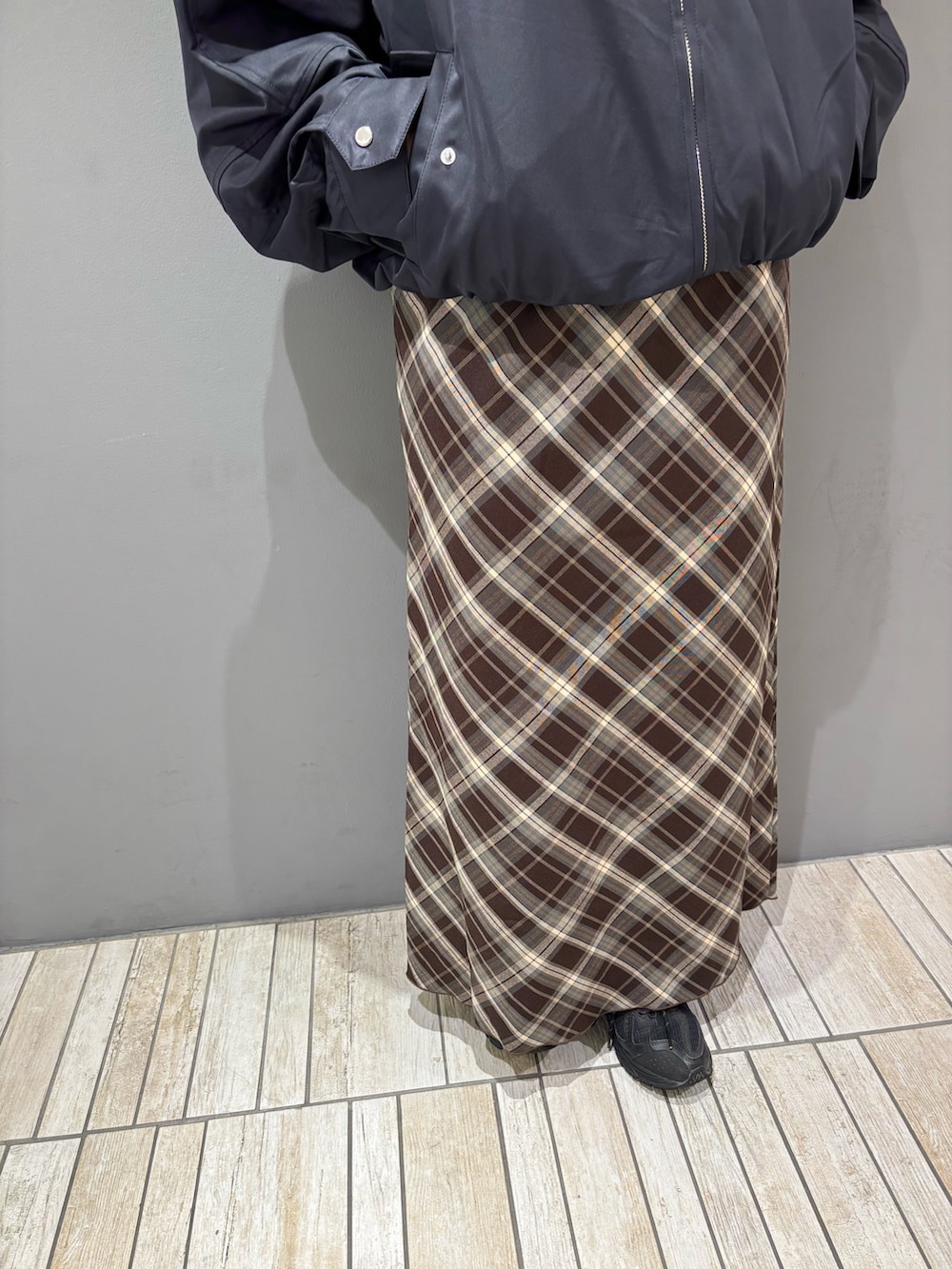 ブルー系のブルゾン、ブラウン系のスカート、ブラック系のメガネを着用したレディースの秋コーディネートの9枚目の写真