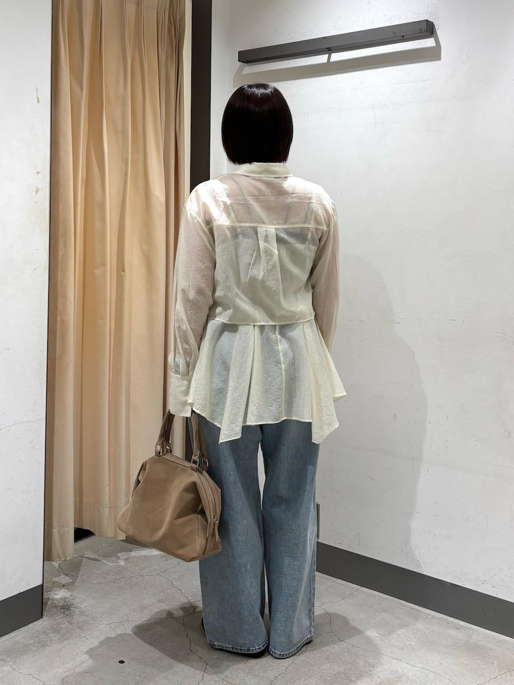 ベージュ系のボストンバッグ、ホワイト系のシャツ/ブラウス、ブルー系のデニムパンツを着用したレディースの春コーディネートの6枚目の写真