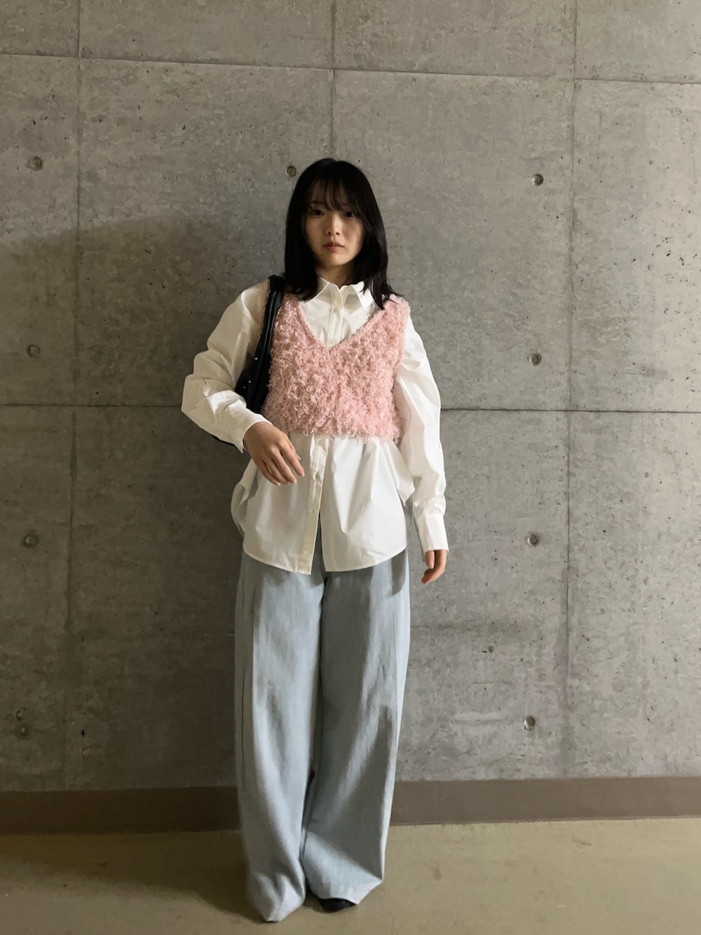 ピンク系のベスト、ホワイト系のシャツ/ブラウス、ブルー系のデニムパンツを着用したレディースの春コーディネートの2枚目の写真