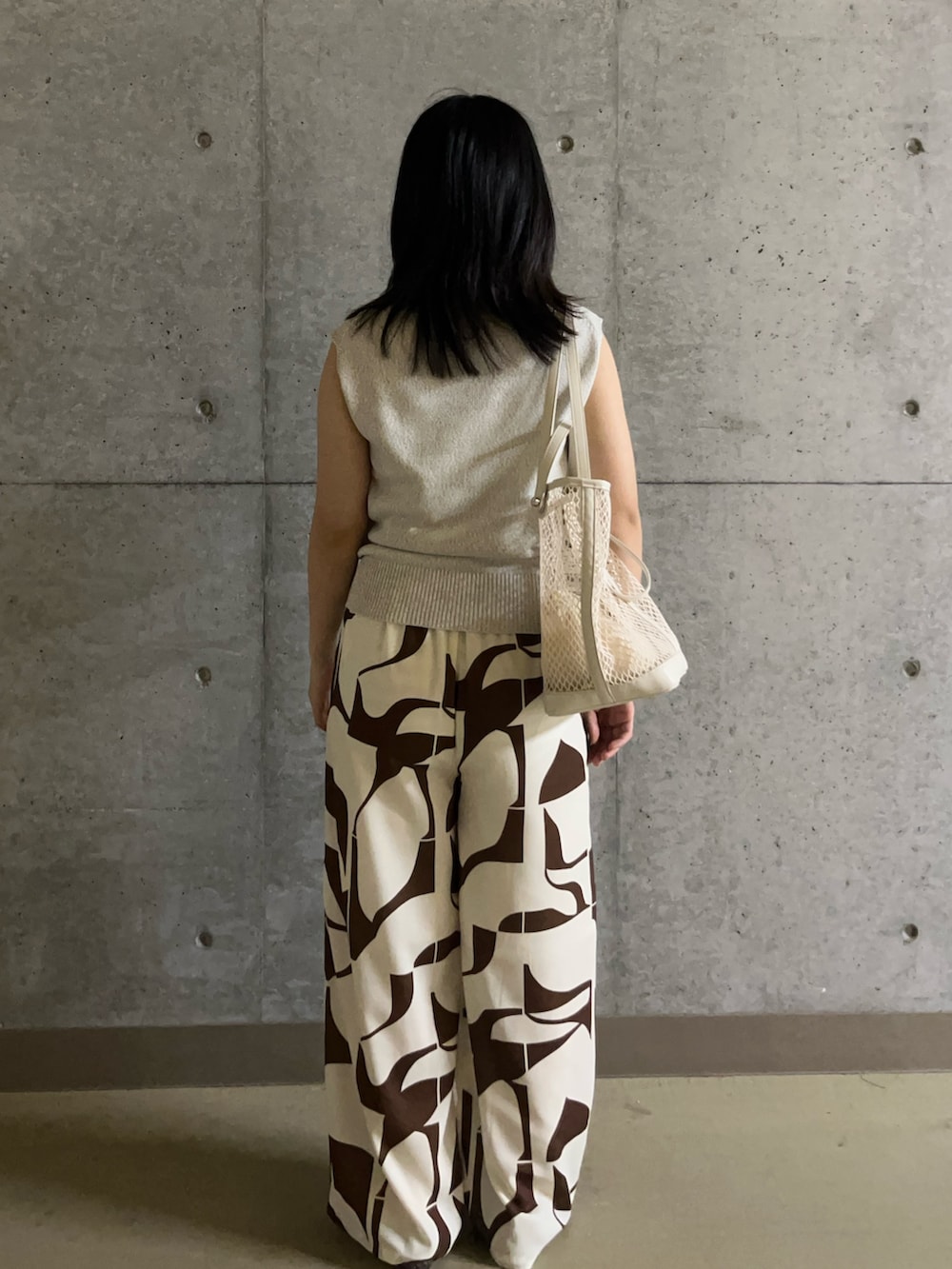 ベージュ系のベスト、ブラウン系のその他パンツ、ホワイト系のトートバッグを着用したレディースの夏コーディネートの2枚目の写真