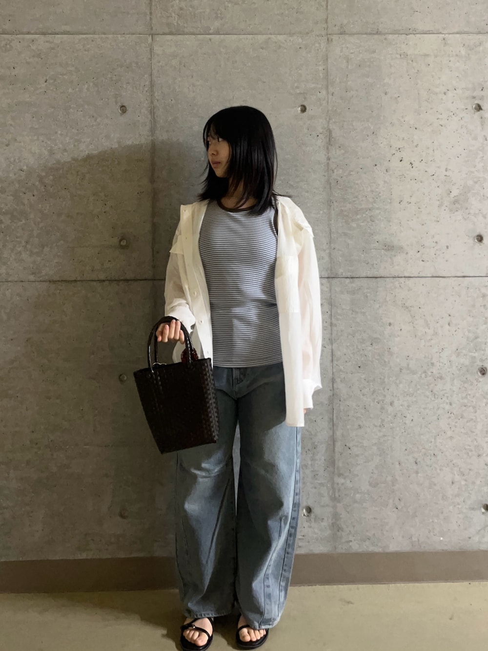 ブルー系のタンクトップ、ホワイト系のシャツ/ブラウス、ブルー系のデニムパンツを着用したレディースの春コーディネートの2枚目の写真