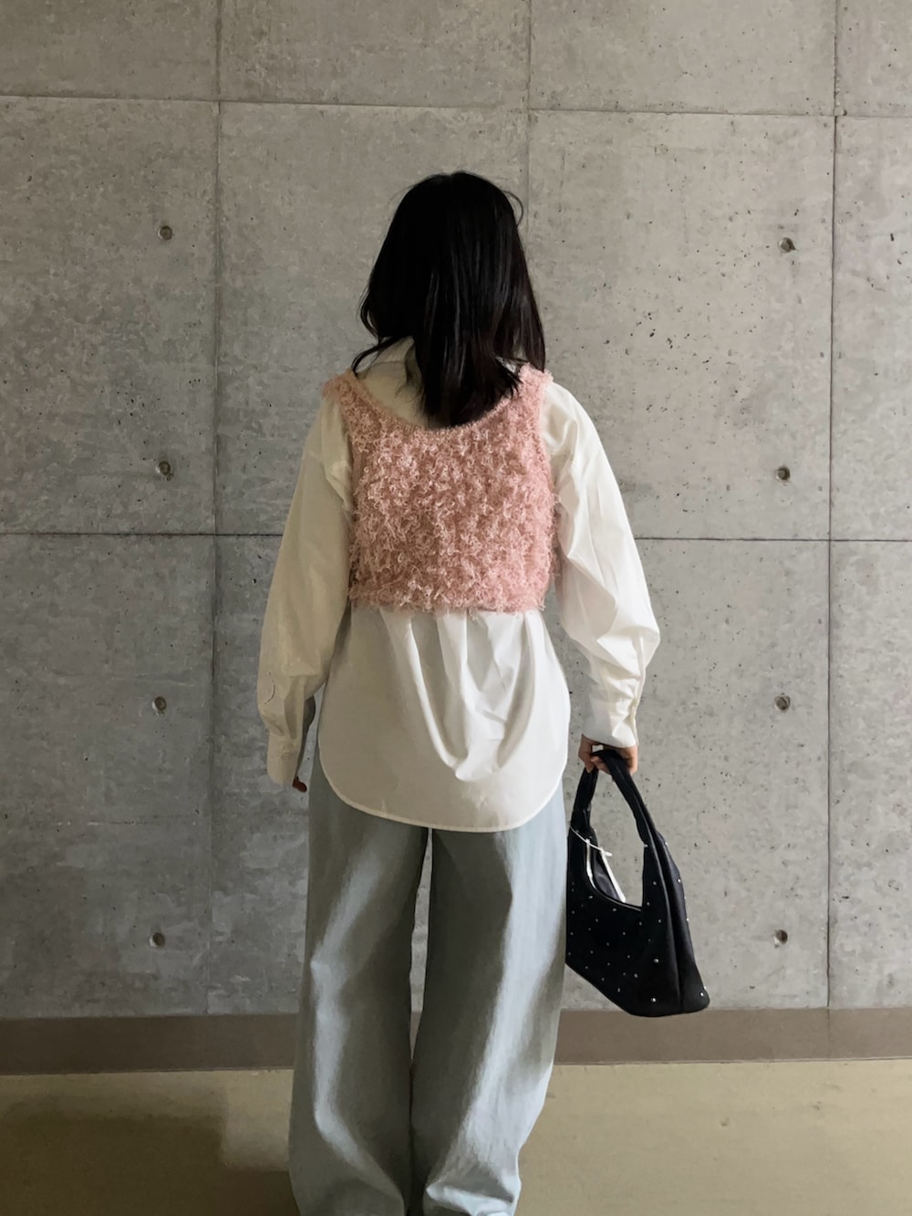 ピンク系のベスト、ホワイト系のシャツ/ブラウス、ブルー系のデニムパンツを着用したレディースの春コーディネートの4枚目の写真