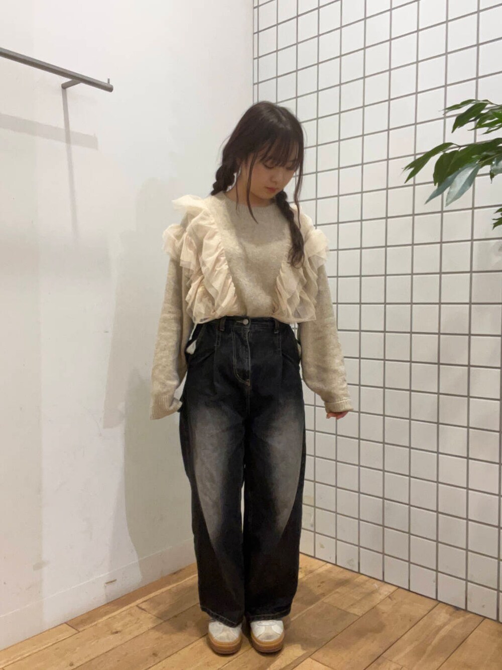 レッド系のダウンジャケット/コート、ブラック系のデニムパンツ、ベージュ系のニット/セーターを着用したレディースの冬コーディネートの4枚目の写真