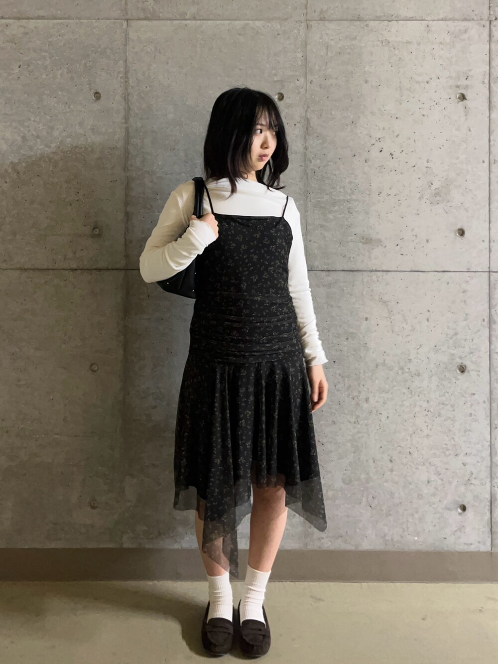 ブラック系のワンピース、ホワイト系のTシャツ/カットソー、ブラウン系のローファーを着用したレディースの春コーディネートの2枚目の写真