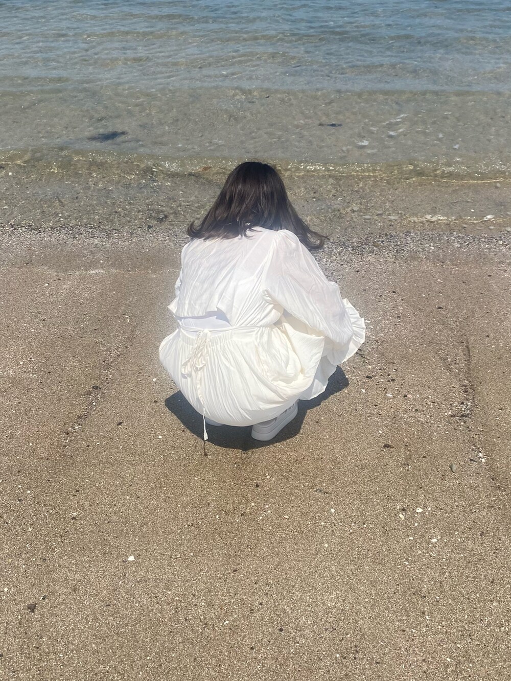 ホワイト系のワンピース、ホワイト系のサンダルを着用したレディースの春コーディネートの2枚目の写真