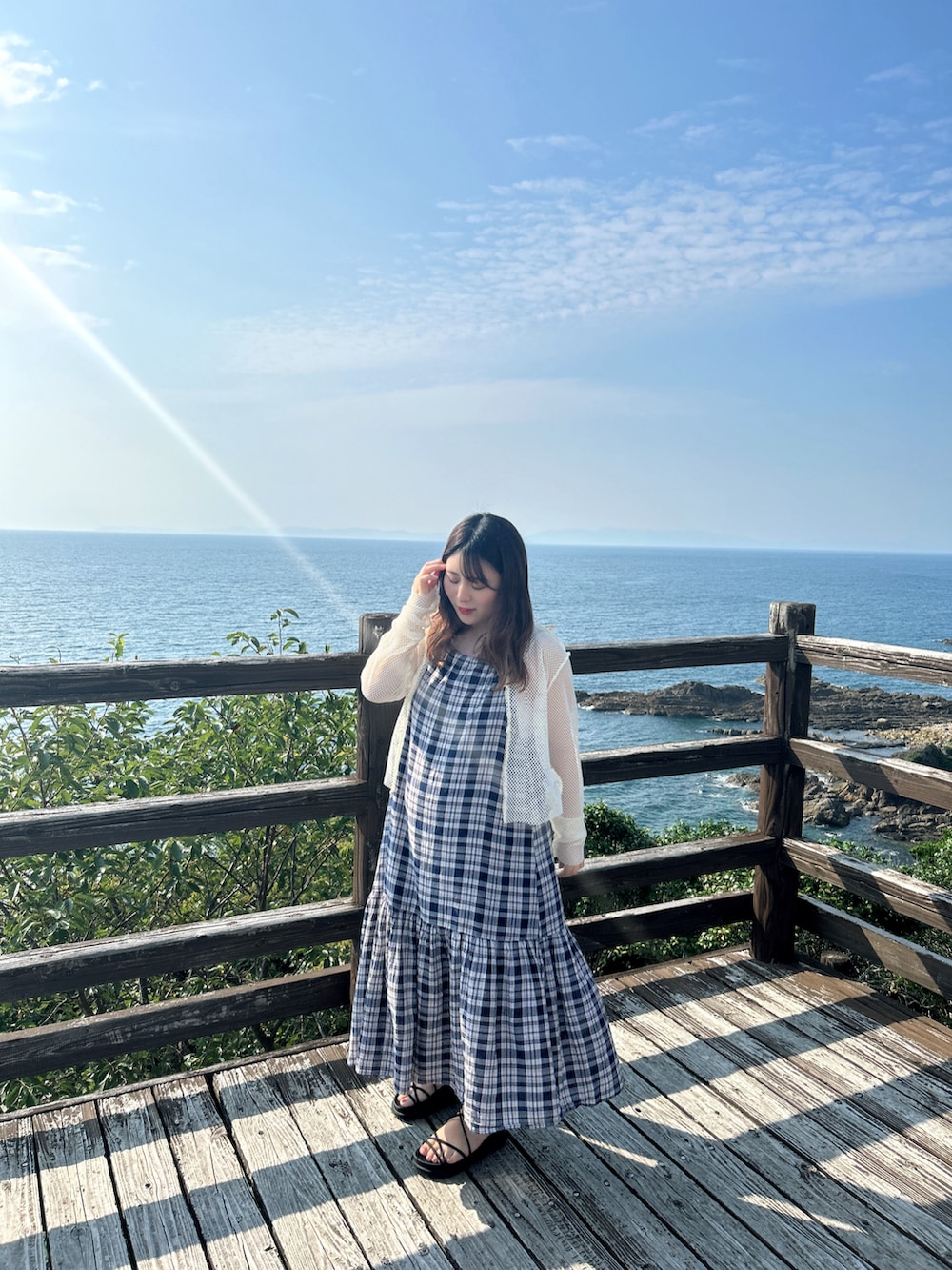 ホワイト系のカーディガン/ボレロ、ブルー系のワンピース、ブラック系のサンダルを着用したレディースの春コーディネートの2枚目の写真