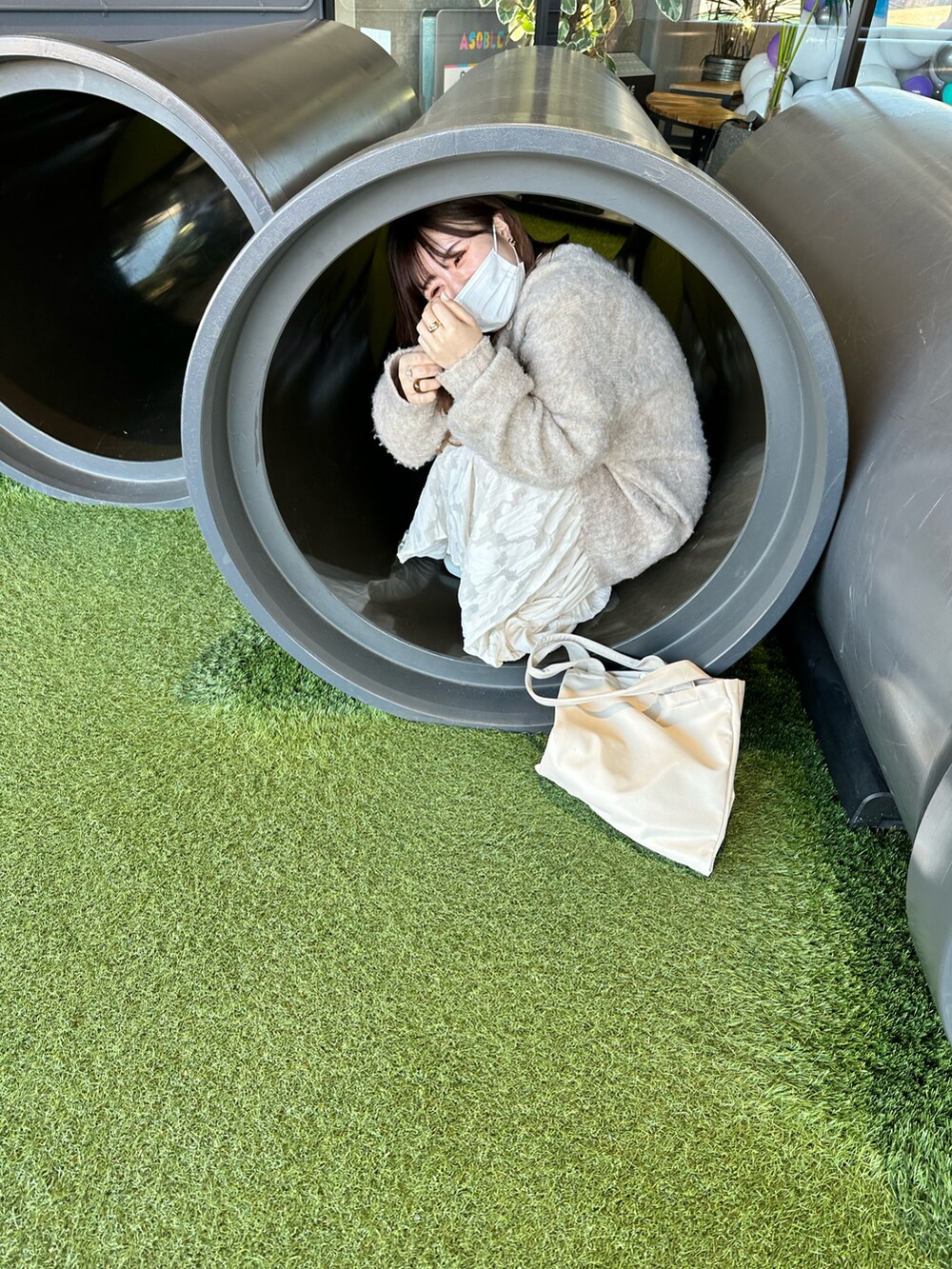 ベージュ系のスニーカー、ホワイト系のワンピース、ホワイト系のトートバッグを着用したレディースの春コーディネートの2枚目の写真