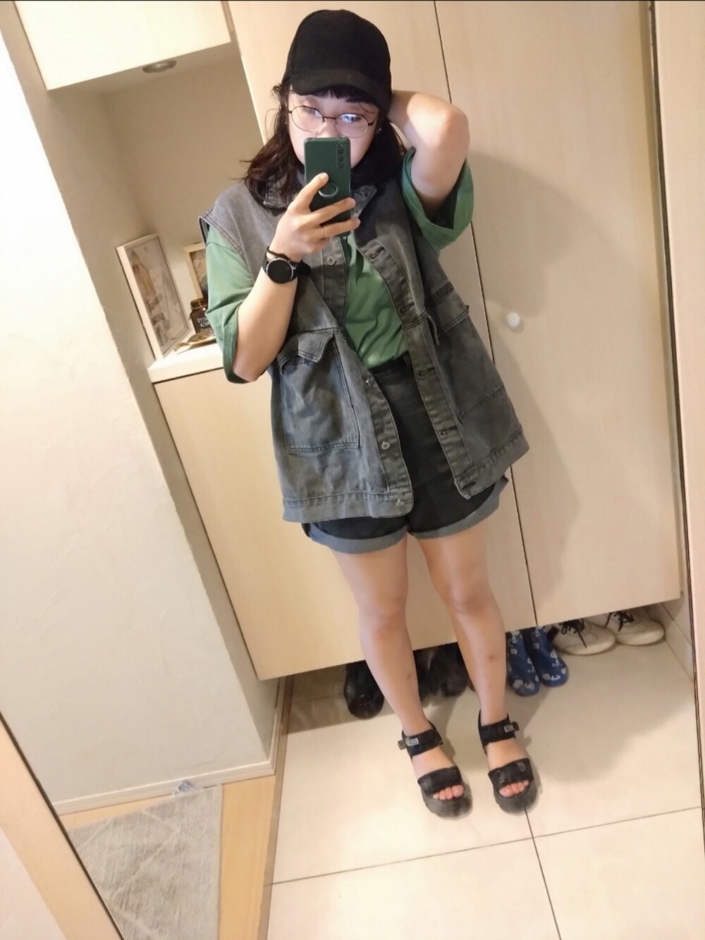 ブルー系のデニムパンツ、ブラック系のサンダルを着用したレディースの夏コーディネートの2枚目の写真